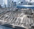 Stainless steel surgical instrument trays laid out on blue drapes in an operating theatre